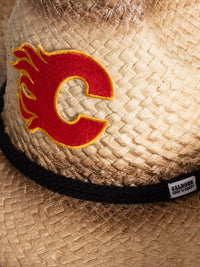 Load image into Gallery viewer, A close up of the front of the Calgary Flames straw cowboy hat. Visible is the team logo, the black rope surrounding the crown of the hat, and the Calhoun Surf &amp; Skate logo.
