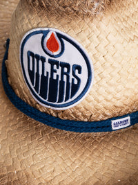 Load image into Gallery viewer, A close up of the front of the Edmonton Oilers straw cowboy hat. Visible is the team logo, the navy rope surrounding the crown of the hat, and the Calhoun Surf &amp; Skate logo.
