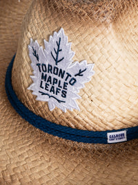 Load image into Gallery viewer, A close up of the front of the Toronto Maple Leafs straw cowboy hat. Visible is the team logo, the navy rope surrounding the crown of the hat, and the Calhoun Surf &amp; Skate logo.
